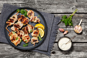 Poster - grilled mini pork skewers on a plate, top view