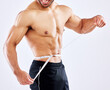 Man, muscle and measuring tape for diet as bodybuilder in competition, strength and wellness on studio backdrop. Healthy, male person and fitness for results, workout and exercise in white background