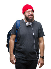 Sticker - Young hipster man wearing red wool cap and backpack over isolated background looking away to side with smile on face, natural expression. Laughing confident.