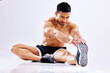 Asian man, studio and stretching legs for workout exercise on ground or floor on white background. Warm up, fitness or sports athlete with flexibility for healthy body, release tension and muscle