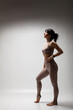 © Nikola Spasenoski - Beautiful caucasian woman in sports exercise outfit. Half silhouette shot of a confident girl standing