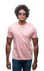 Poster - Afro american man wearing sunglasses over isolated background with serious expression on face. Simple and natural looking at the camera.