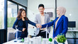 © Phushutter - Three businesspeople gather at a desk, symbolizing unity with joined hands. Led by a middle-aged Asian man and woman, they strategize sustainable solutions for a cleaner, energy-efficient future.