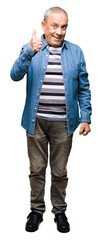 Sticker - Handsome senior man wearing denim jacket doing happy thumbs up gesture with hand. Approving expression looking at the camera with showing success.