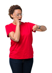 Wall Mural - Beautiful young african american woman wearing glasses over isolated background Looking at the watch time worried, afraid of getting late