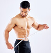 Man, fitness and measuring tape for diet as bodybuilder in competition, strength and wellness on studio backdrop. Healthy, male person and muscle for results, workout and exercise in white background
