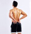 Man, injury and back pain in studio from accident, fitness or body exercise isolated on white background. Spine, muscle problem and model with arthritis, fibromyalgia or fatigue from sports workout