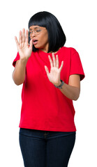 Wall Mural - Beautiful young african american woman wearing glasses over isolated background afraid and terrified with fear expression stop gesture with hands, shouting in shock. Panic concept.