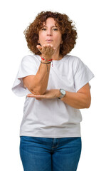 Poster - Beautiful middle ager senior woman wearing white t-shirt over isolated background looking at the camera blowing a kiss with hand on air being lovely and sexy. Love expression.