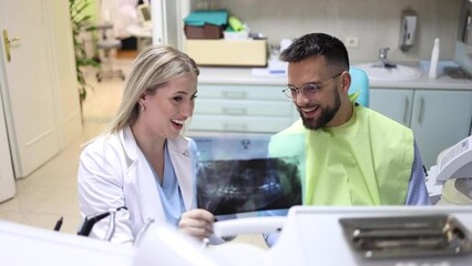 Wall Mural - Dentist showing the x-ray to her patient