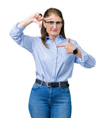 Canvas Print - Beautiful middle age mature business woman wearing glasses over isolated background smiling making frame with hands and fingers with happy face. Creativity and photography concept.