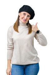 Canvas Print - Middle age mature woman wearing winter sweater and beret over isolated background doing happy thumbs up gesture with hand. Approving expression looking at the camera showing success.