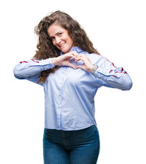 Wall Mural - Beautiful brunette curly hair young girl wearing elgant look over isolated background smiling in love showing heart symbol and shape with hands. Romantic concept.