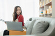© MrAshi - Young Asian business woman smiles and uses laptop to check information on shipping box before sending it to customer. Small business entrepreneur, SME online marketing, delivery concept