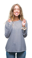 Sticker - Beautiful young blonde woman wearing stripes sweater over isolated background smiling crossing fingers with hope and eyes closed. Luck and superstitious concept.