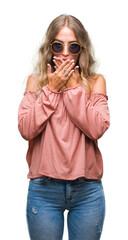 Canvas Print - Beautiful young blonde woman wearing retro sunglasses over isolated background shocked covering mouth with hands for mistake. Secret concept.