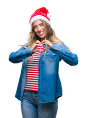 Poster - Beautiful young blonde woman wearing christmas hat over isolated background smiling in love showing heart symbol and shape with hands. Romantic concept.