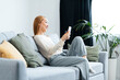 Relaxed Young Woman Enjoying Online Shopping On Smartphone In Comfortable Living Room, Modern Home Decor, Casual Lifestyle