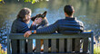 © peopleimages.com - Couple, dog and back on park bench, outdoor and relax by lake for connection, care or touch on holiday. Man, woman and pet animal by water with German shepherd for trust, vacation or nature in winter