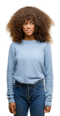 Canvas Print - African american woman wearing a sweater smiling looking side and staring away thinking.