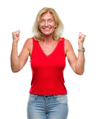 Sticker - Middle age blonde woman over isolated background celebrating surprised and amazed for success with arms raised and open eyes. Winner concept.