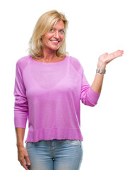 Sticker - Middle age blonde woman over isolated background smiling cheerful presenting and pointing with palm of hand looking at the camera.