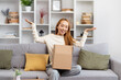 Happy Young Woman Unboxing Parcel In Living Room, Excited Female Sitting On Sofa, Lifestyle Home Concept, Online Shopping, Relocation