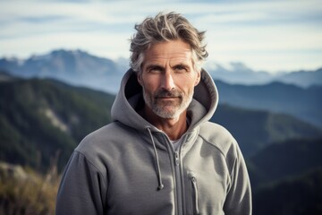 Wall Mural - Portrait of a blissful man in his 50s wearing a zip-up fleece hoodie while standing against panoramic mountain vista