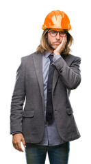 Wall Mural - Young handsome architec man with long hair wearing safety helmet over isolated background thinking looking tired and bored with depression problems with crossed arms.