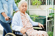 Caregiver help Asian elderly woman disability patient sitting on wheelchair in hospital, medical concept.