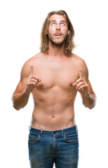 Sticker - Young handsome shirtless man with long hair showing sexy body over isolated background amazed and surprised looking up and pointing with fingers and raised arms.