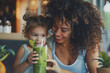 © Dmitrii - Woman and Little Girl Holding Green Smoothie. Generative AI