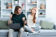 Happy Couple Shopping Online At Home: Asian Woman And Caucasian Man Excited By Purchase, Cozy Living Room.