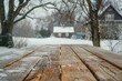 A wooden table with snow on it in front of a house. The table is empty and the snow is covering the ground