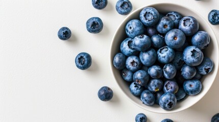 Wall Mural - A bowl of blueberries is on a white background. The bowl is filled with blueberries, and there are many of them
