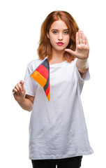 Canvas Print - Young beautiful woman holding flag of germany over isolated background with open hand doing stop sign with serious and confident expression, defense gesture