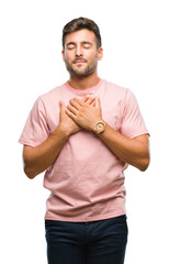 Wall Mural - Young handsome man over isolated background smiling with hands on chest with closed eyes and grateful gesture on face. Health concept.