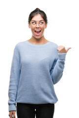 Poster - Young beautiful hispanic woman wearing a bun pointing and showing with thumb up to the side with happy face smiling