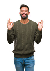 Wall Mural - Adult hispanic man wearing winter sweater over isolated background relax and smiling with eyes closed doing meditation gesture with fingers. Yoga concept.