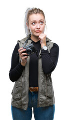 Poster - Young blonde woman taking pictures using vintage camera over isolated background serious face thinking about question, very confused idea