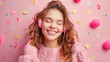 Joyous young girl enjoying music with pink headphones against a festive background
