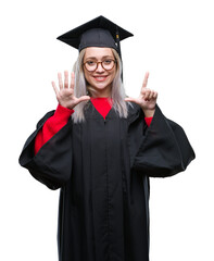 Wall Mural - Young blonde woman wearing graduate uniform over isolated background showing and pointing up with fingers number seven while smiling confident and happy.