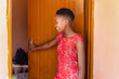black teenager going to school village township in south africa, entering the room to pick her school bag