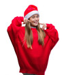 © Krakenimages.com - Young beautiful girl wearing christmas hat over isolated background smiling confident showing and pointing with fingers teeth and mouth. Health concept.
