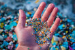 Close up human hand with colored microplastic. Concept of plastic pollution.
