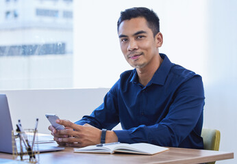 Poster - Man, portrait and business in office with smartphone, typing and company for online mission statement and review. Employee, social media and website search, information technology with professional