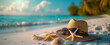 Sun hat, sunglasses, and starfish on tropical beach at sunset