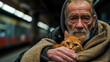 Elderly man with ginger cat in subway, wrapped in brown blanket