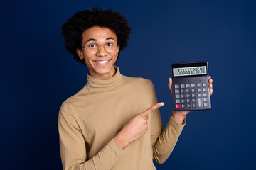 Canvas Print - Photo portrait of nice young man hold point calculator wear trendy beige outfit isolated on dark blue color background