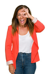 Poster - Beautiful middle age business adult woman over isolated background doing ok gesture with hand smiling, eye looking through fingers with happy face.